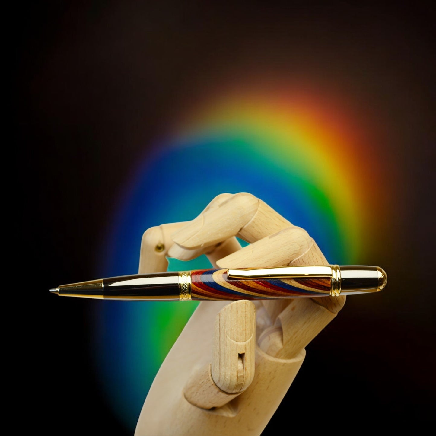 Handcrafted Rainbow Wood ballpoint pen with gold and black titanium trim, handmade in Ireland and presented in a luxury gift box